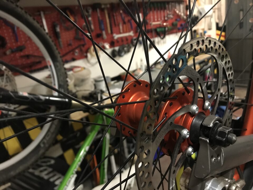 Tra le ruote delle bici si intravvede il banco officina per la bicicletta
